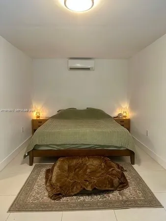 a bed sitting in a bedroom and kitchen