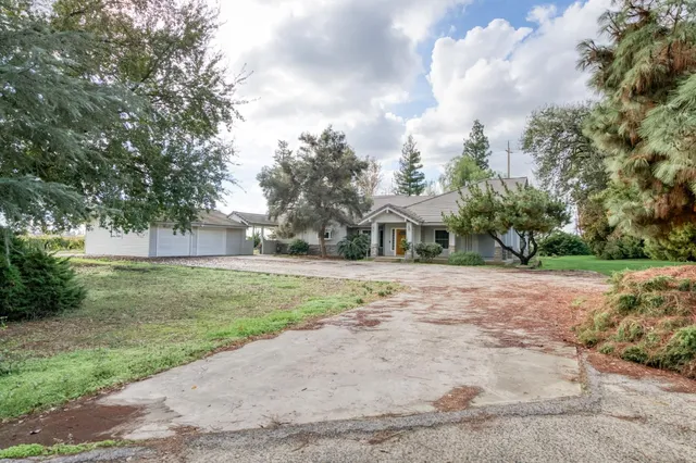a front view of a house with a yard and trees