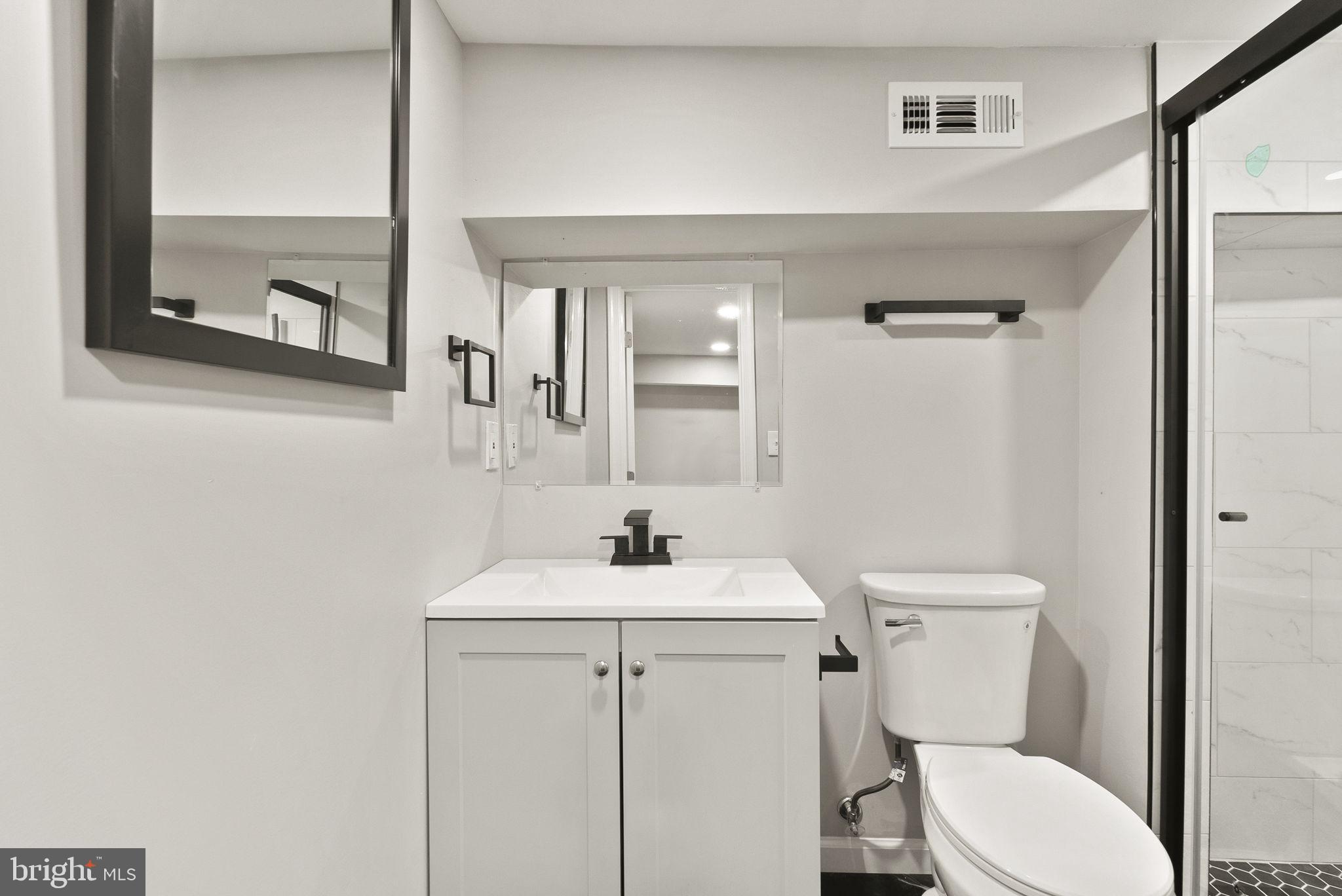 6314 7th Street Northwest Washington, DC 20011 - Photo 13 of 19 a bathroom with a toilet sink vanity and mirror