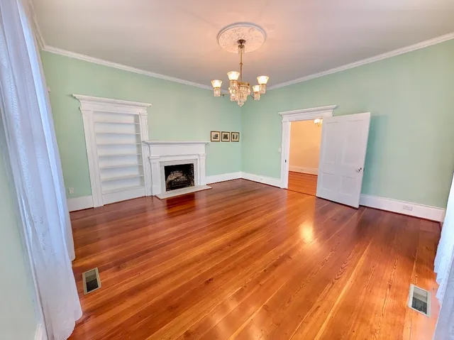 wooden floor in an empty room with a fireplace