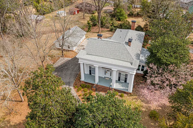 an aerial view of a house with large trees