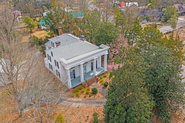 an aerial view of a house with large trees