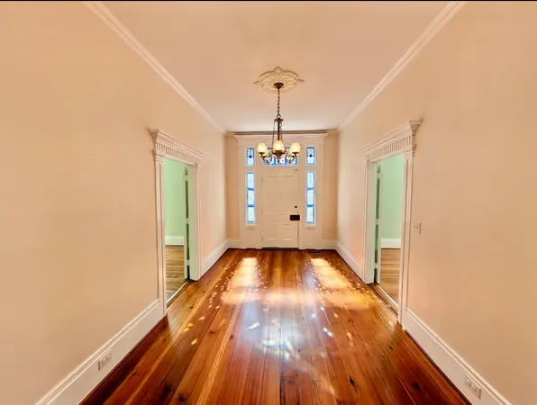 a view of a room with wooden floor staircase and a kitchen