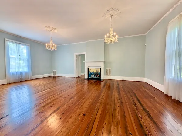 a view of empty room with wooden floor fireplace and window
