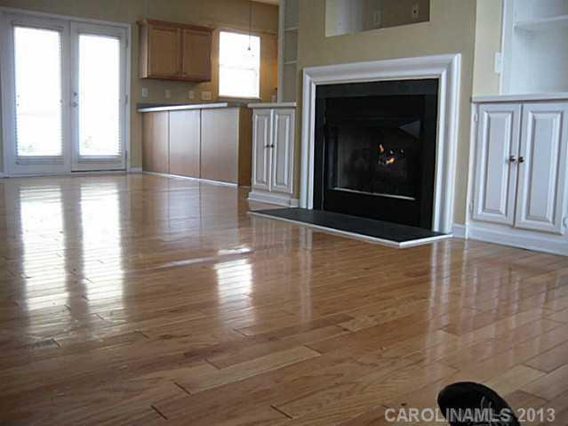 8236 Townley Road Huntersville, NC 28078 - Photo 8 of 10 an empty room with wooden floor fireplace and windows