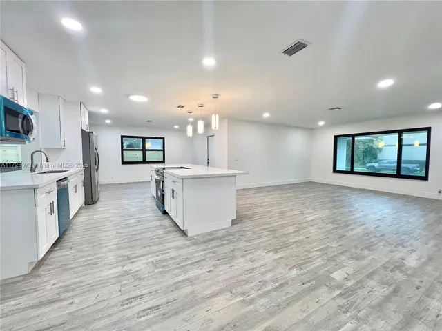 a view of a kitchen with a sink and microwave