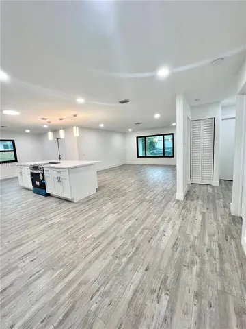 a view of a kitchen with a sink and wooden floor