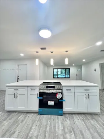 a kitchen with a stove sink and cabinets