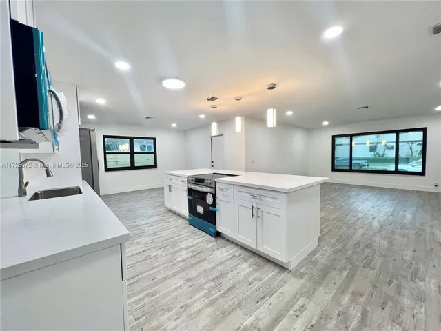 a large white kitchen with a large window