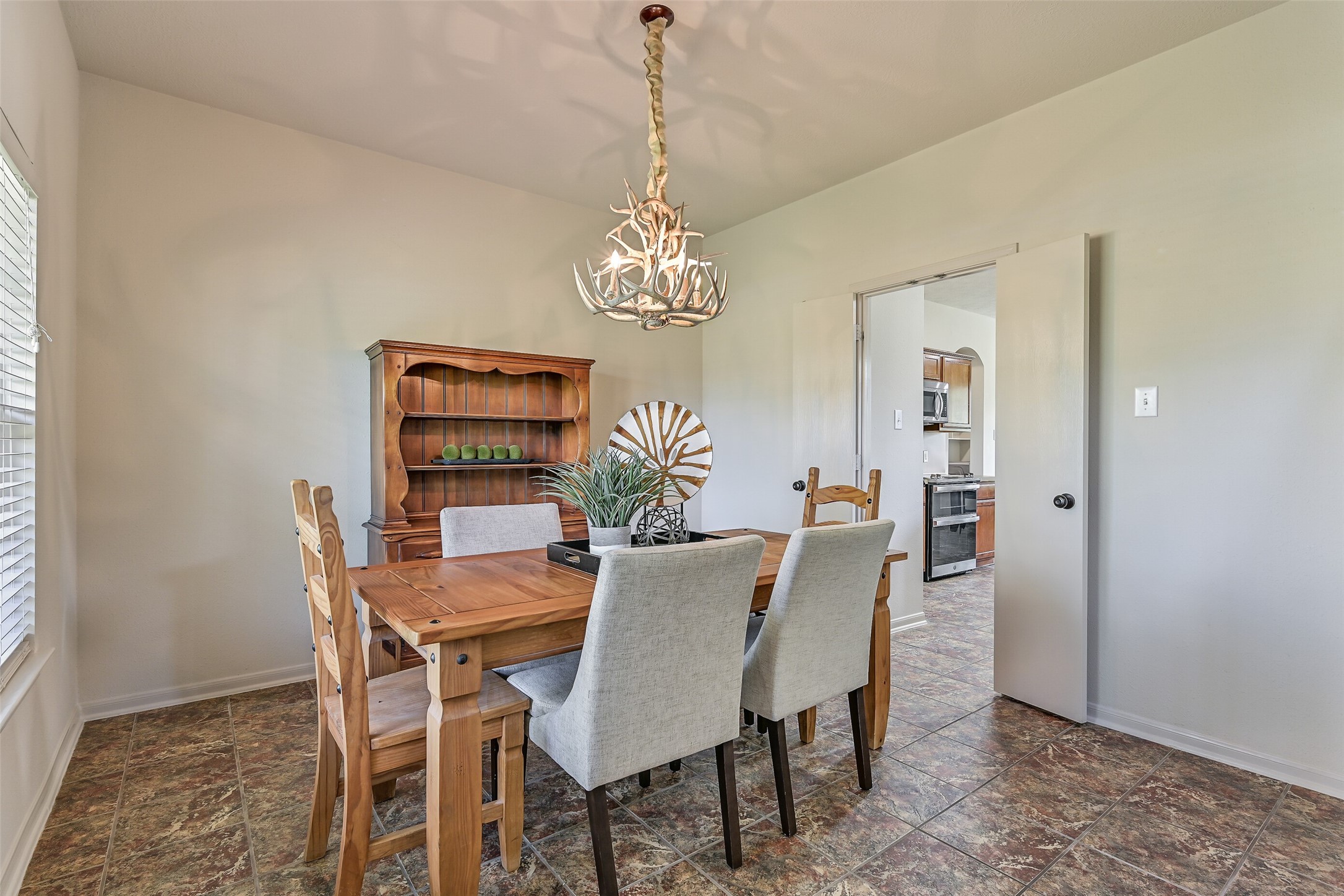 1404 Hollier Road Friendswood, TX 77546 - Photo 12 of 46 The dining area offers a seamless connection to the kitchen, making everyday meals and hosting effortless. Neutral finishes, tile flooring, and elevated ceilings maintain a cohesive look while allowing each space to feel defined.