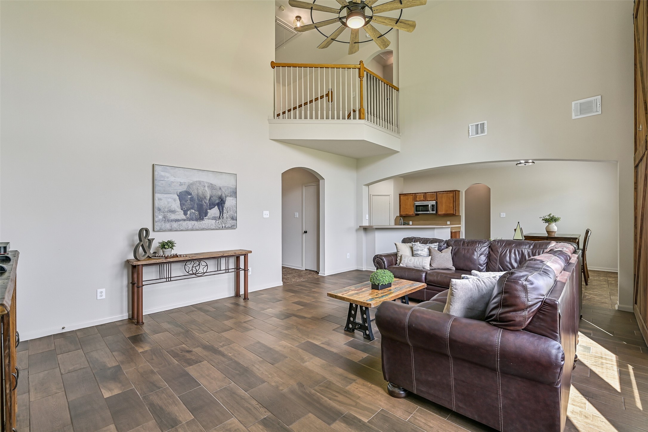1404 Hollier Road Friendswood, TX 77546 - Photo 15 of 46 From this angle, the open concept design truly shines, with the family room flowing effortlessly toward the dining and kitchen areas. Elevated ceilings and an overlook from the second floor enhance the spacious feel throughout.