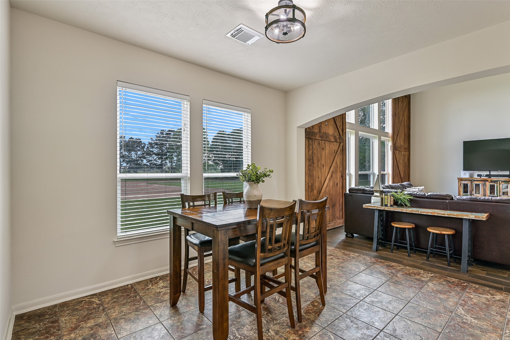1404 Hollier Road Friendswood, TX 77546 - Photo 16 of 46 Transition into the breakfast area where large windows bring in natural light and peaceful views of the surrounding acreage. This casual dining space feels bright and connected to the outdoors, perfect for starting the day.