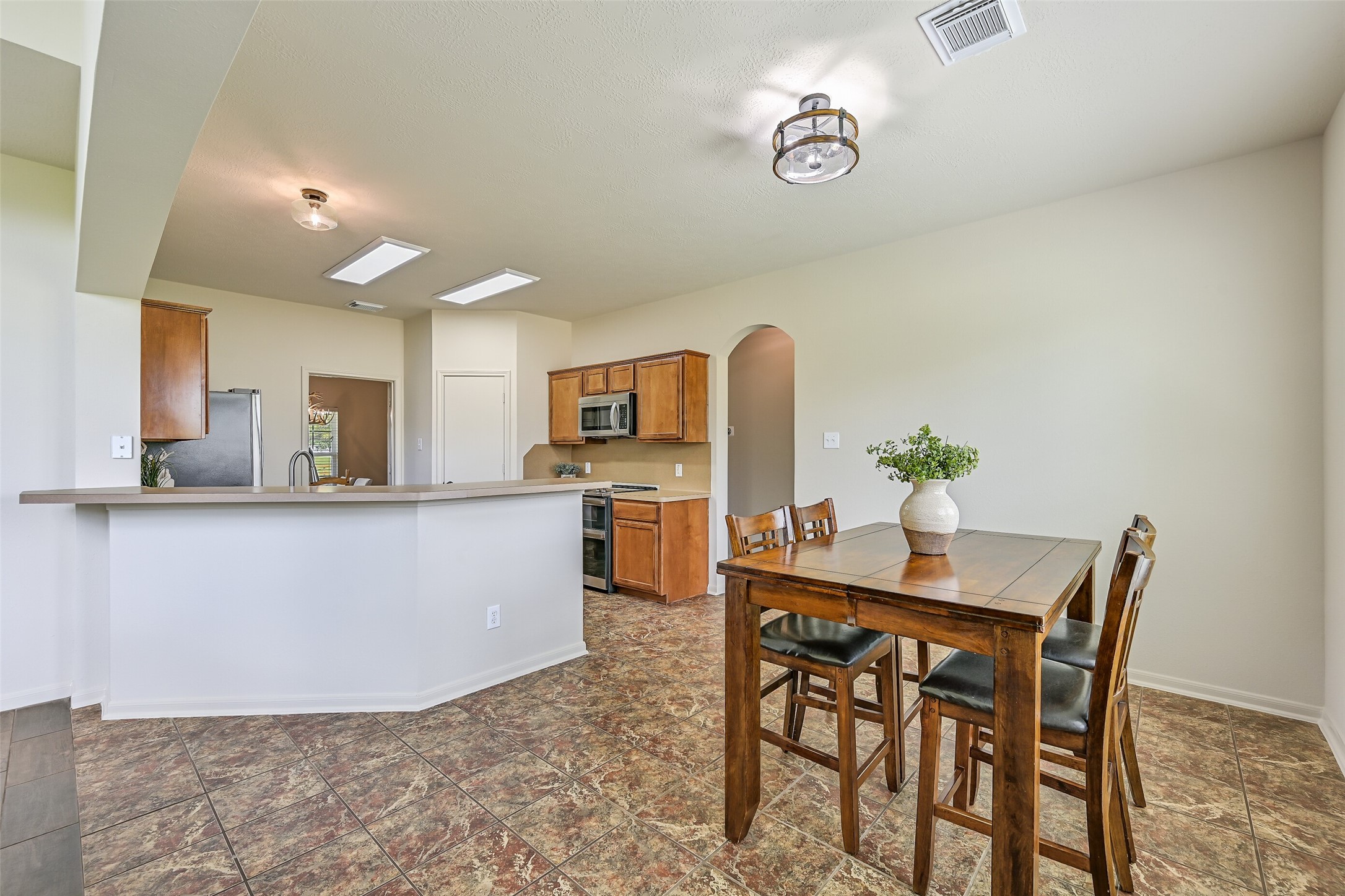 1404 Hollier Road Friendswood, TX 77546 - Photo 17 of 46 Another look at the breakfast area shows its convenient location just off the main living space, offering easy access while still feeling tucked into its own light-filled corner. Neutral finishes and tile flooring keep the space clean and cohesive.