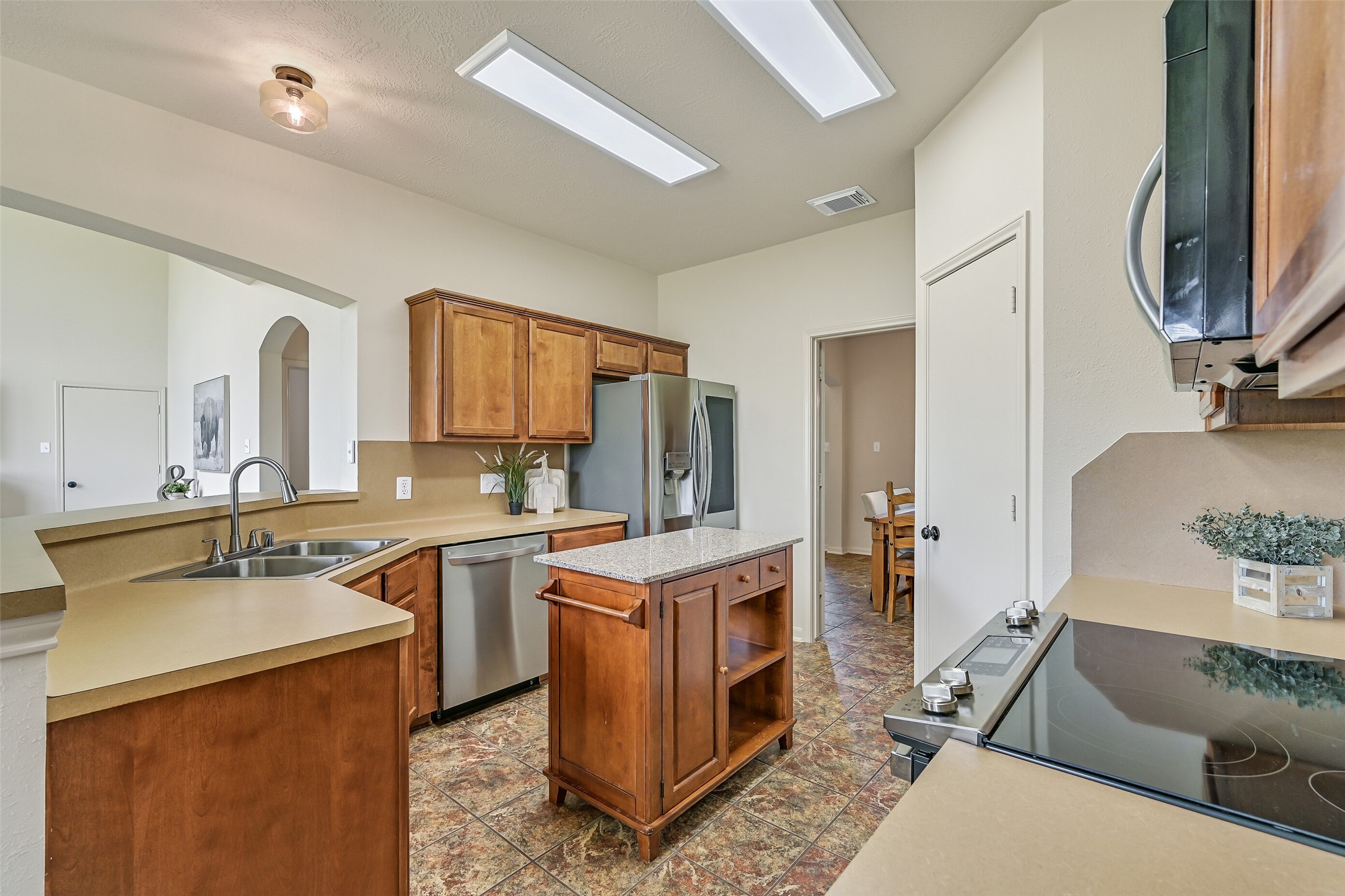 1404 Hollier Road Friendswood, TX 77546 - Photo 18 of 46 The kitchen features a functional layout with ample counter space, a wrap-around breakfast bar, and a movable island for added flexibility. Stainless appliances, including dual ovens, and generous cabinetry support both daily use and larger gatherings.