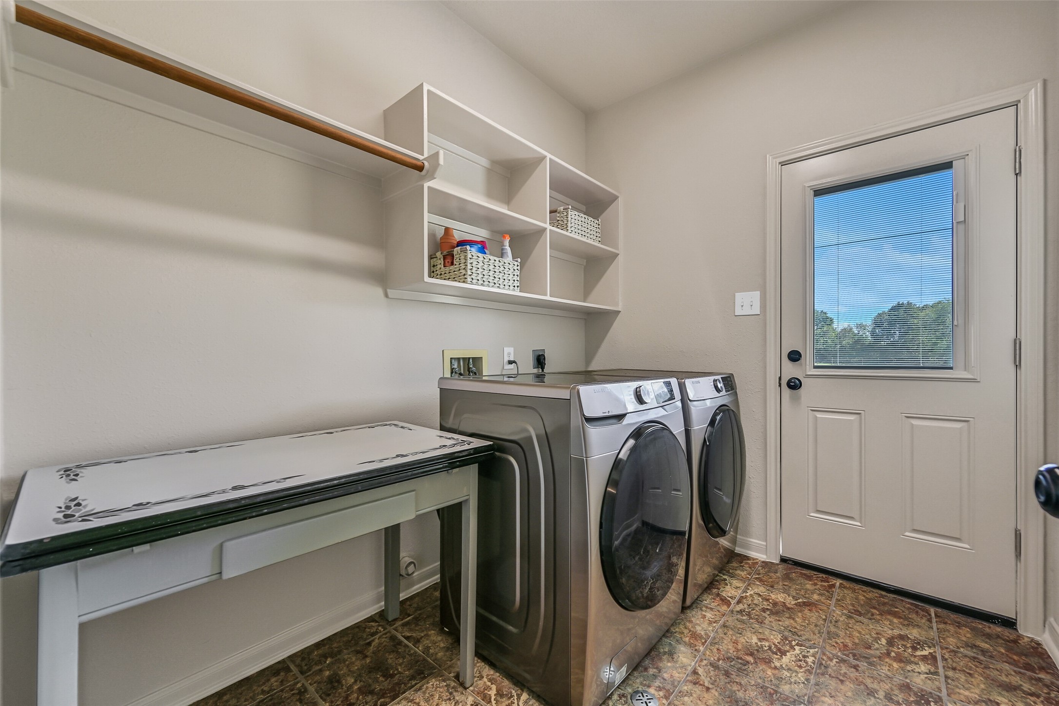 1404 Hollier Road Friendswood, TX 77546 - Photo 21 of 46 The utility room offers plenty of space for full-size washer and dryer, along with additional room for a second refrigerator or freezer. Built-in shelving and direct exterior access add to the functionality of this hardworking space.