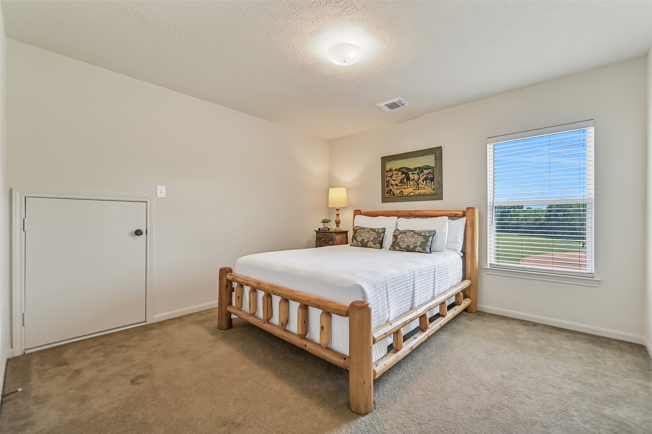 1404 Hollier Road Friendswood, TX 77546 - Photo 26 of 46 Upstairs, this secondary bedroom offers a comfortable layout with soft natural light and views of the surrounding acreage. Neutral tones and carpeted flooring make the space easy to personalize.
