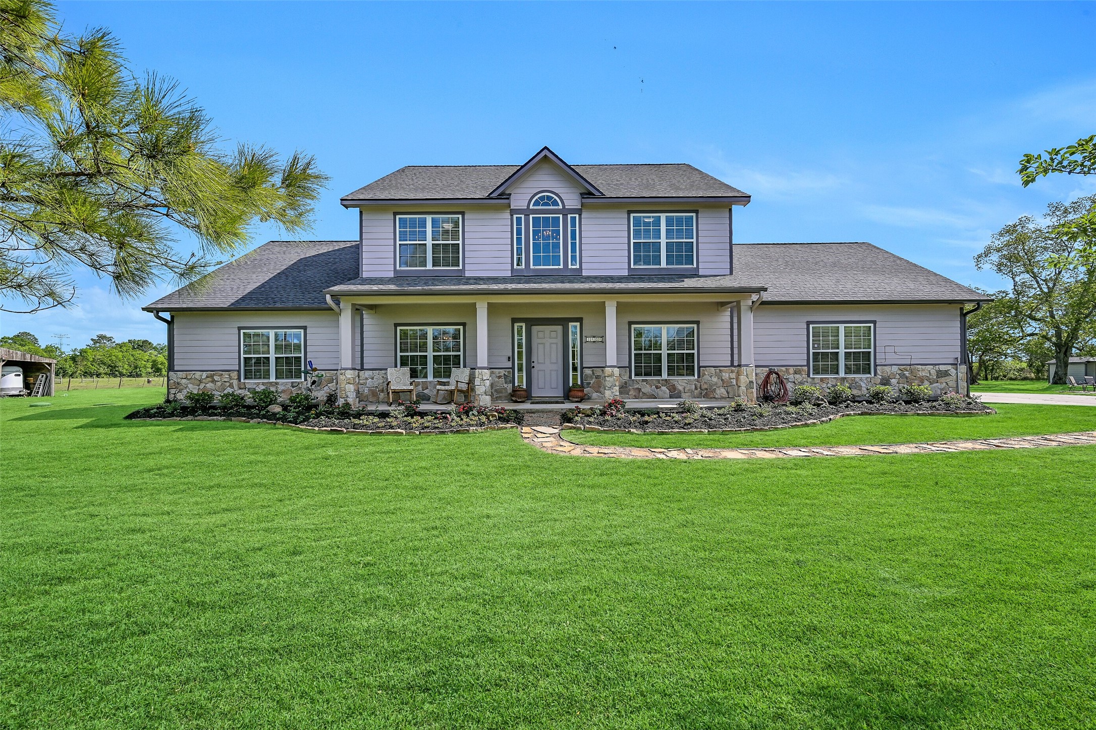 1404 Hollier Road Friendswood, TX 77546 - Photo 3 of 46 Set on 6+ tree-lined acres, this well-maintained 2601 SF home offers a peaceful country setting with no HOA restrictions. The stone and Hardie plank exterior, new 2024 roof, and expansive lawn create a welcoming first impression with room to grow and roam.