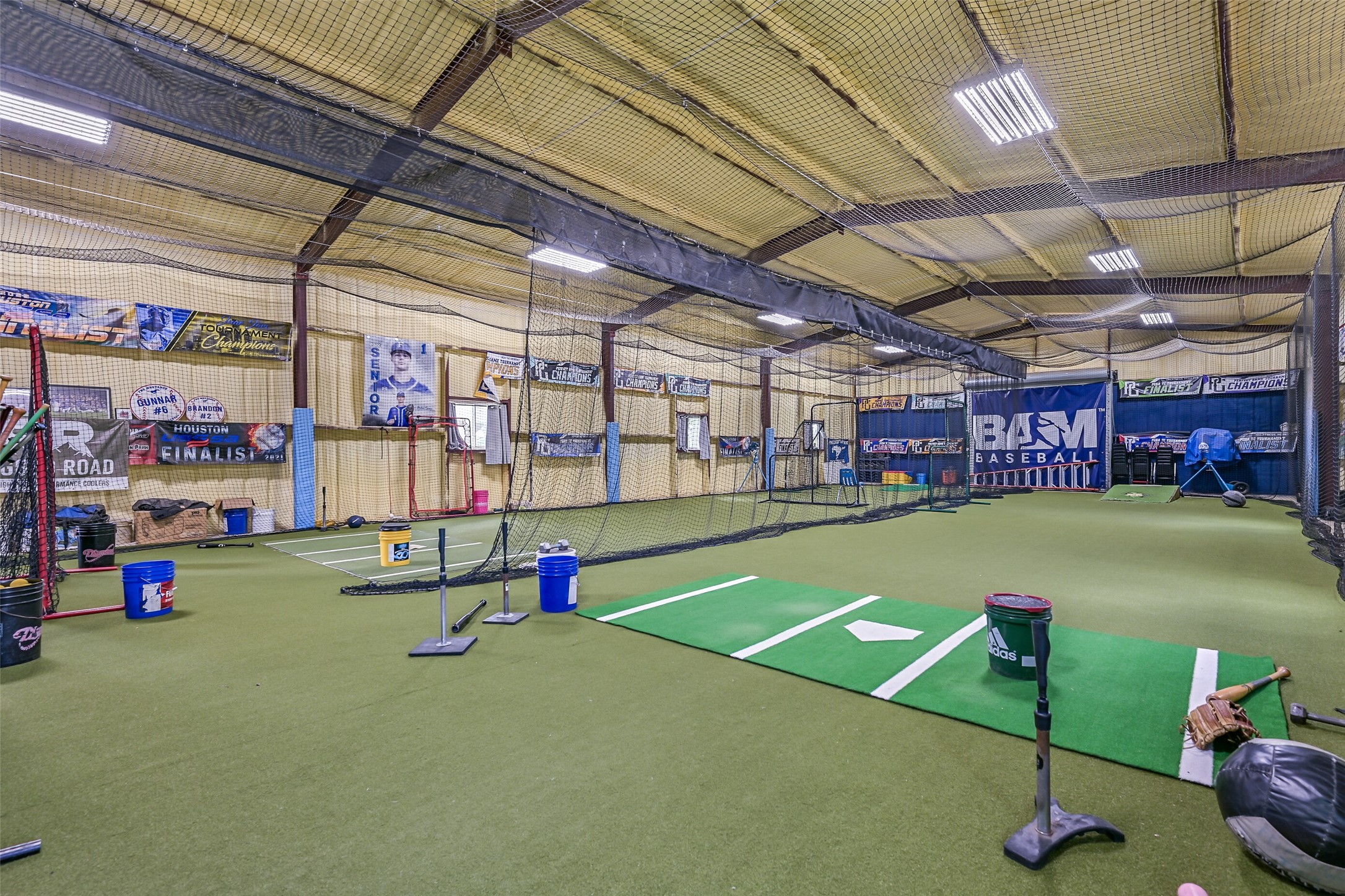 1404 Hollier Road Friendswood, TX 77546 - Photo 34 of 46 Inside the metal building, the fully enclosed training setup currently includes turf flooring, netting, and lighting throughout. Climate control via dual mini-split systems allows for year-round use.