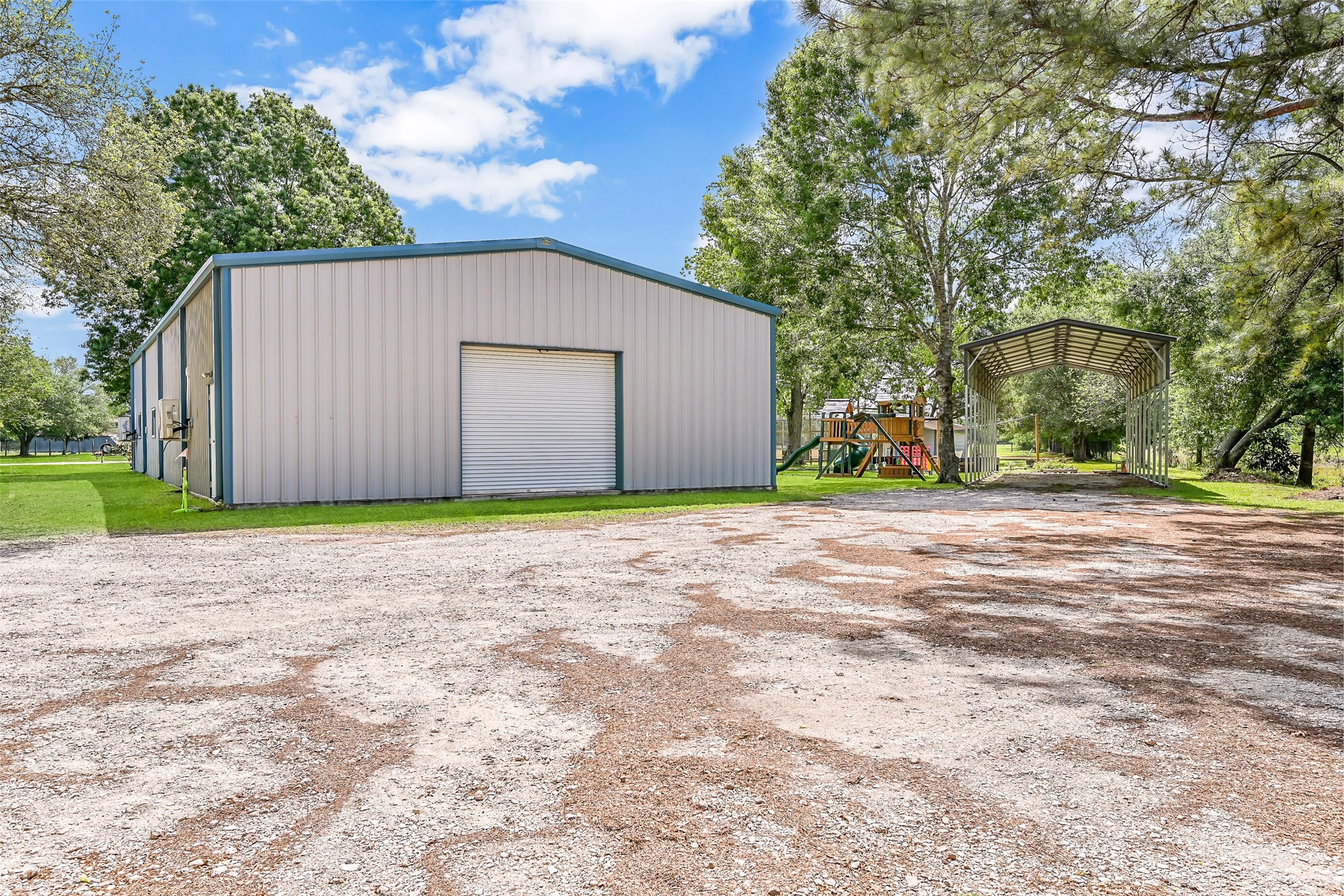 1404 Hollier Road Friendswood, TX 77546 - Photo 35 of 46 The rear of the 40’x80’ insulated metal building highlights additional access and dedicated parking space, currently supporting a baseball training setup. With wide clearance and room to maneuver, this area is well-suited for business use, equipment, or storage.