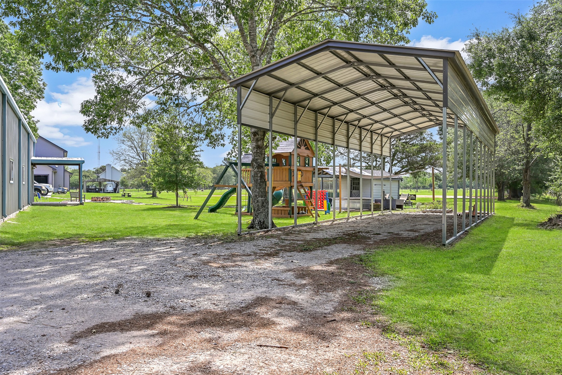 1404 Hollier Road Friendswood, TX 77546 - Photo 36 of 46 Covered RV parking measures approximately 45 feet deep, 16 feet wide, and 14 feet high, offering ample space for larger vehicles, trailers, or equipment. Positioned near the metal building, this setup adds convenience and flexibility for storage or travel needs.