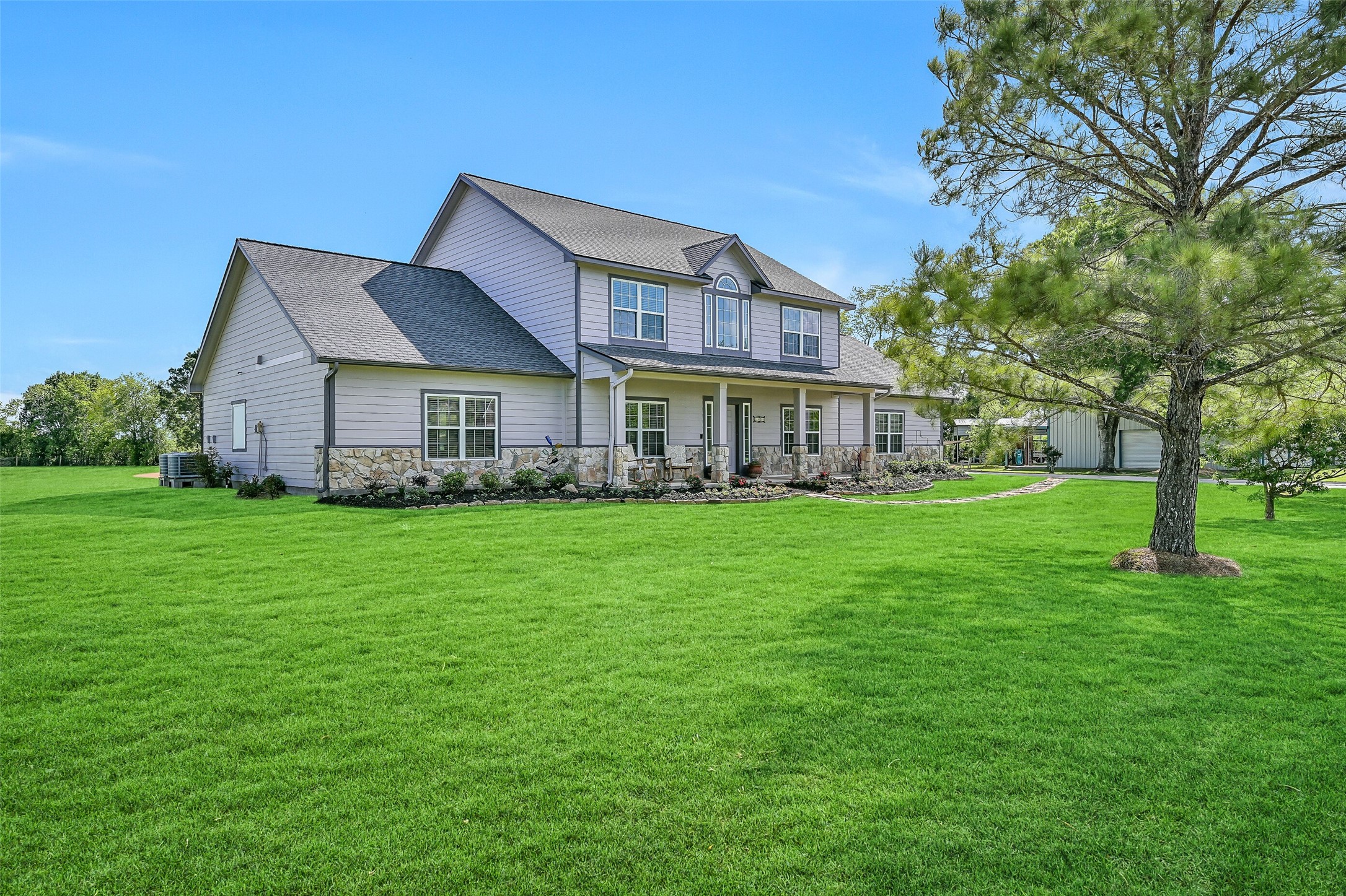 1404 Hollier Road Friendswood, TX 77546 - Photo 4 of 46 A wide, inviting front elevation highlights the home’s balanced design with double-paned windows, fresh landscaping, and a charming covered porch. The setting feels private and open, offering a rare combination of space, functionality, and freedom.