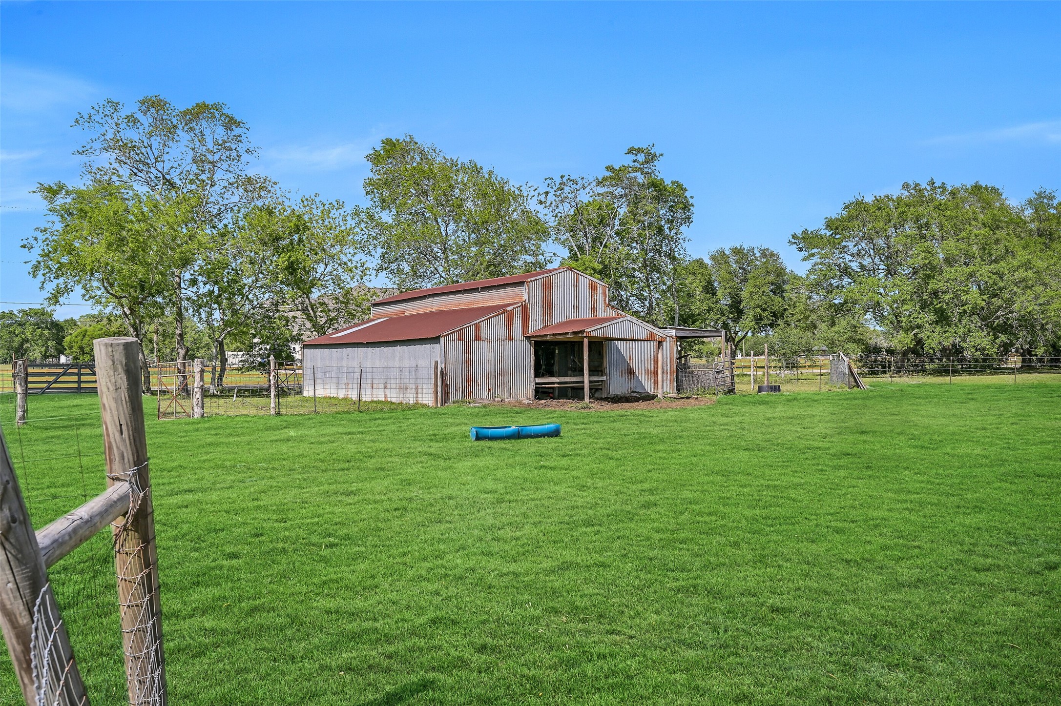 1404 Hollier Road Friendswood, TX 77546 - Photo 42 of 46 The barn includes 7 stalls and a dedicated feed room with a concrete floor, offering a solid setup for livestock. Positioned within the fenced pasture, it supports a true working property feel.