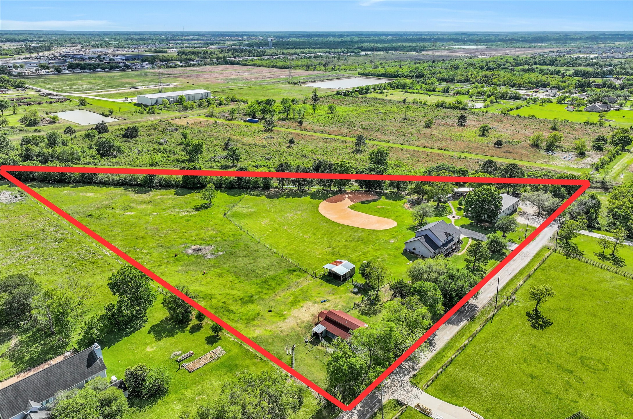 1404 Hollier Road Friendswood, TX 77546 - Photo 44 of 46 From this angle, the property’s layout becomes even more apparent, with the residence, outbuildings, & recreational areas all thoughtfully positioned across the acreage. No HOA restrictions allow for a wide range of potential uses.