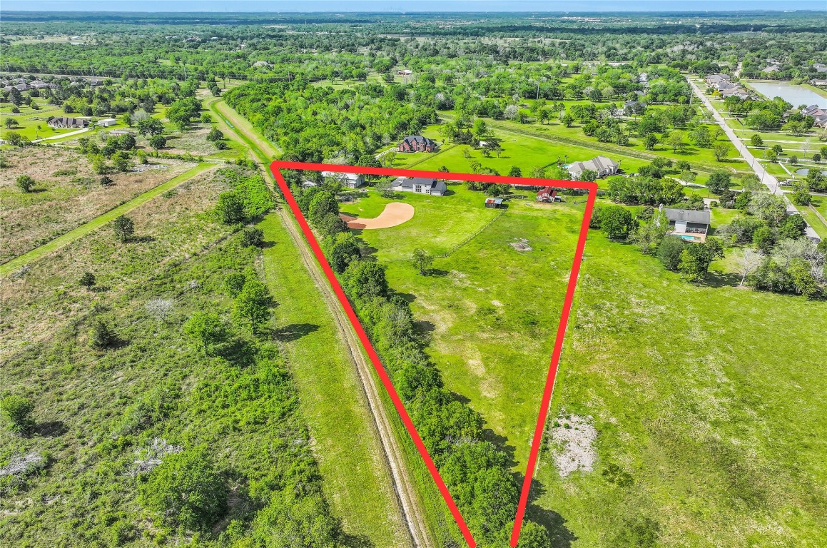 1404 Hollier Road Friendswood, TX 77546 - Photo 45 of 46 A broader aerial highlights the surrounding area, with the property situated along the Galveston County and Brazoria County border. Nearby acreage properties and open land contribute to the quiet, rural feel while still being accessible to nearby amenities.