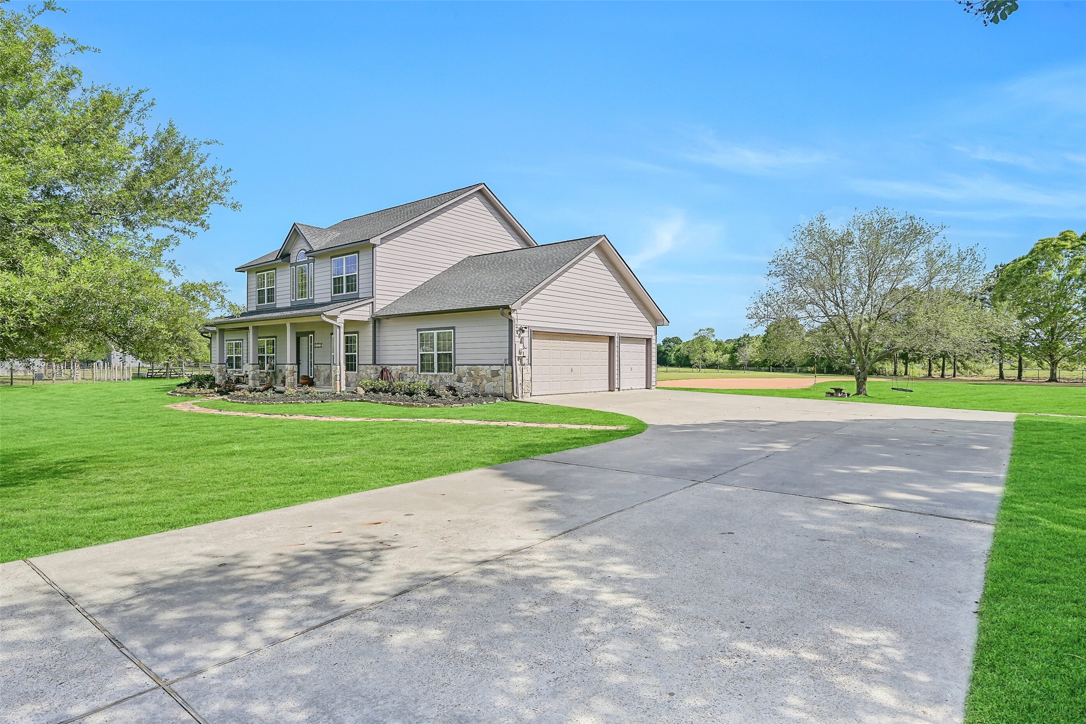 1404 Hollier Road Friendswood, TX 77546 - Photo 5 of 46 A long drive leads to the attached 3-car garage, with plenty of additional parking for guests, equipment, or recreational vehicles. The surrounding acreage and open skies reinforce the versatility of this property beyond just the home.