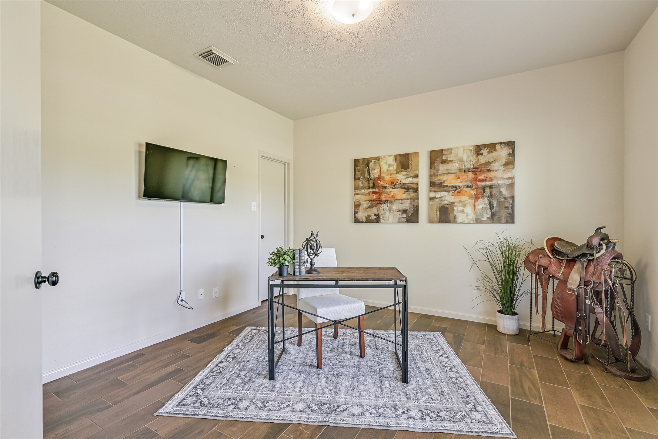 1404 Hollier Road Friendswood, TX 77546 - Photo 9 of 46 Just off the entry, a dedicated study offers a quiet and functional workspace with wood-look flooring and neutral tones. A large window frames views of the surrounding acreage, creating an ideal setting for working from home.