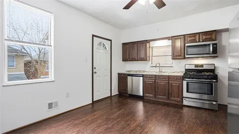 a kitchen with stainless steel appliances granite countertop a stove a sink and a microwave