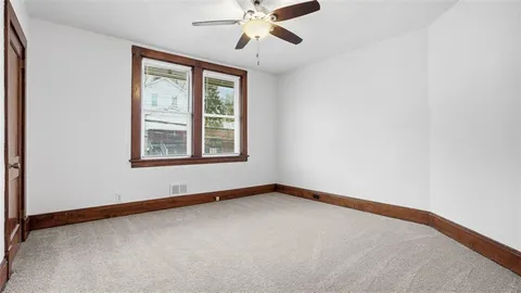 an empty room with windows and fan