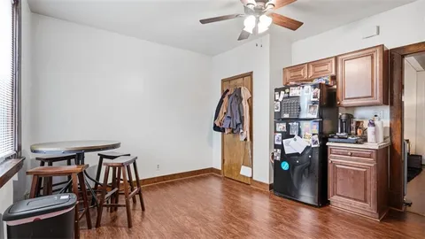 a view of a kitchen with fridge and wooden floor