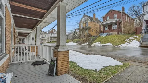 a view of a brick house with many windows next to a road