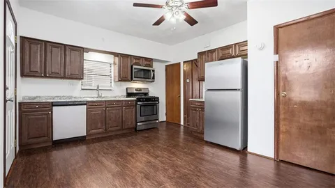 a kitchen with a refrigerator and a stove top oven