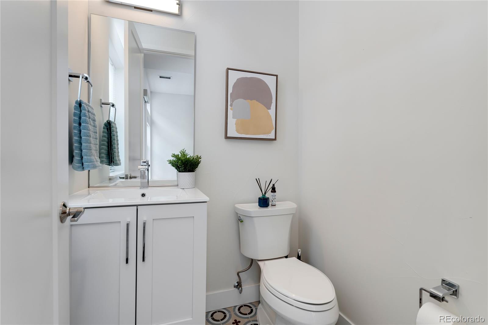 1587 Perry Street Denver, CO 80204 - Photo 13 of 37 a bathroom with a toilet a sink and mirror