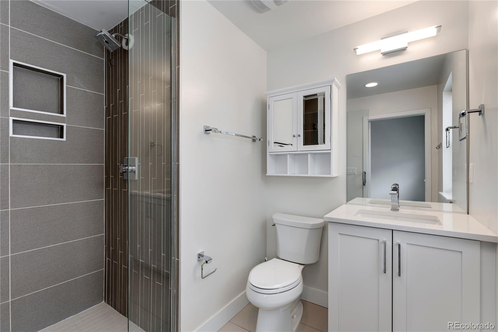 1587 Perry Street Denver, CO 80204 - Photo 17 of 37 a bathroom with a toilet sink and mirror