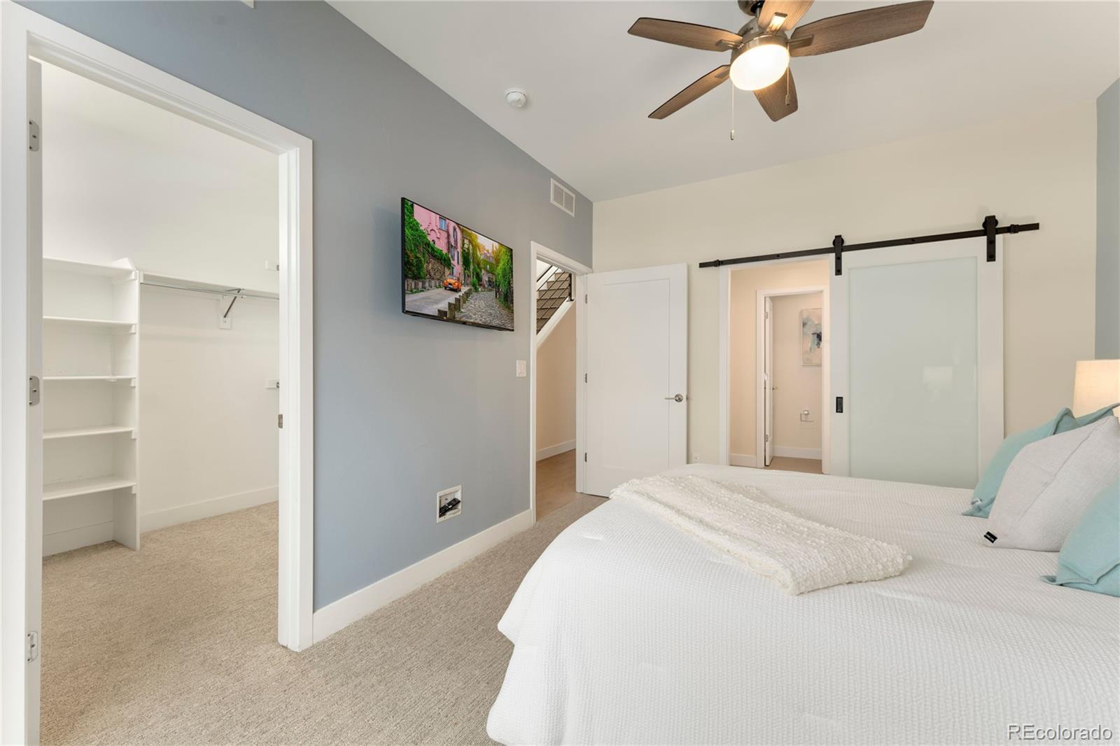 1587 Perry Street Denver, CO 80204 - Photo 20 of 37 a bedroom with a bed and a walk in closet