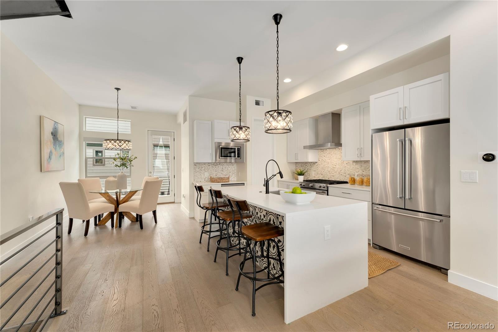 1587 Perry Street Denver, CO 80204 - Photo 2 of 37 a kitchen with stainless steel appliances a refrigerator a stove a dining table chairs and wooden floor
