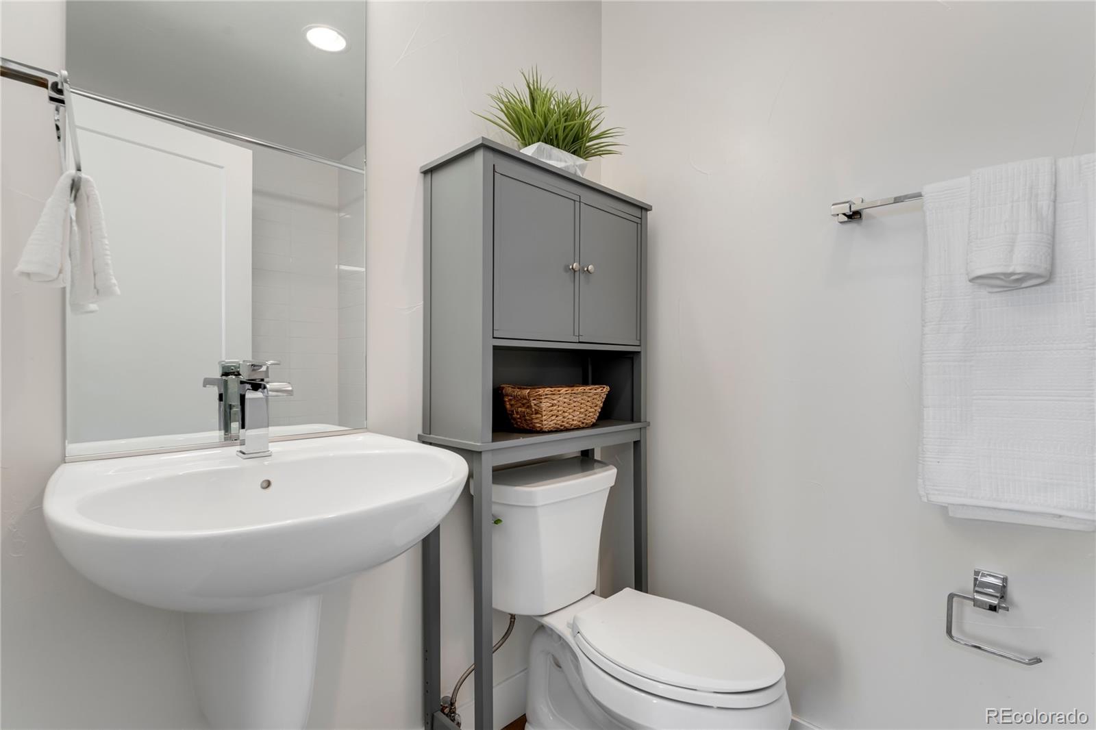 1587 Perry Street Denver, CO 80204 - Photo 30 of 37 a bathroom with a sink a toilet and a mirror
