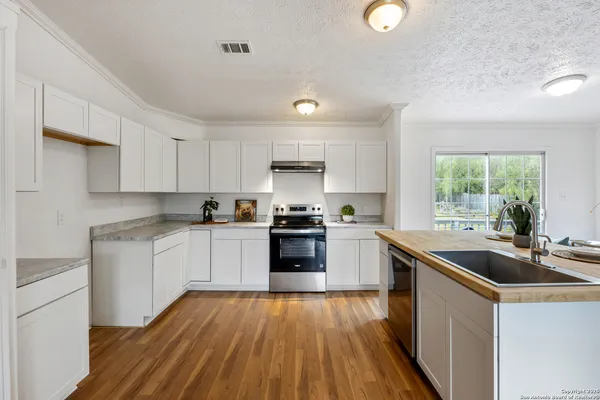 a kitchen with a sink a stove a microwave and cabinets