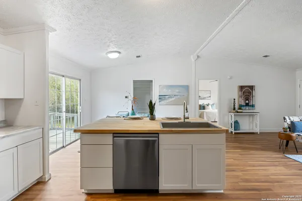 a view of a kitchen counter top space with stainless steel appliances wooden floor and cabinets