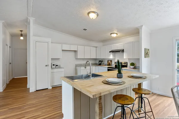 a kitchen with a dining table chairs and white cabinets