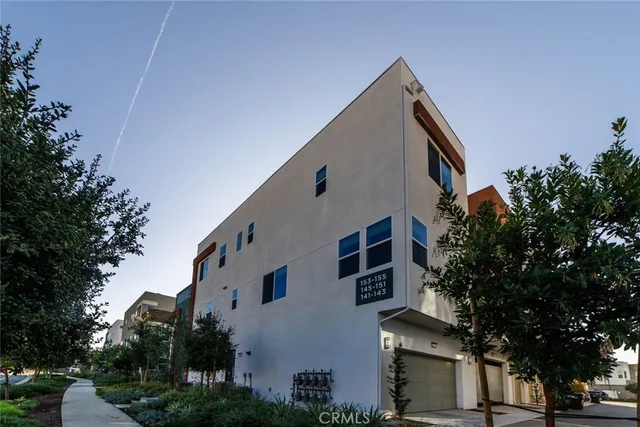 a front view of a house with a tree