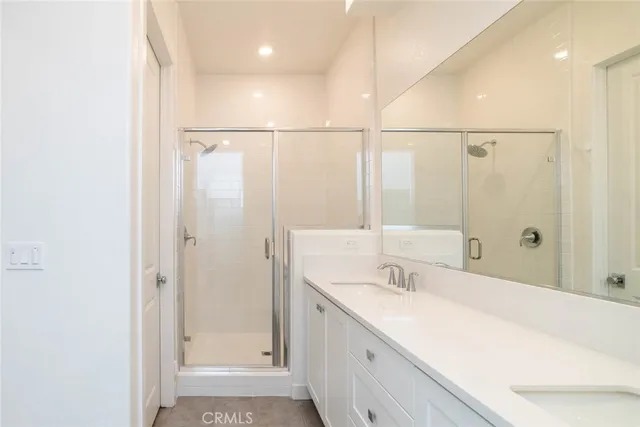a bathroom with a granite countertop sink a mirror and a shower