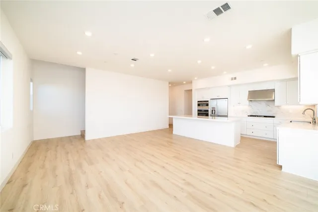 a view of kitchen with stainless steel appliances kitchen island a refrigerator sink and cabinets
