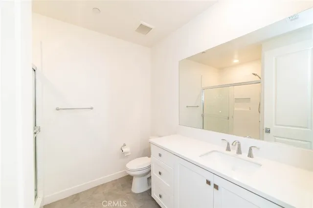 a bathroom with a sink a toilet and a large mirror