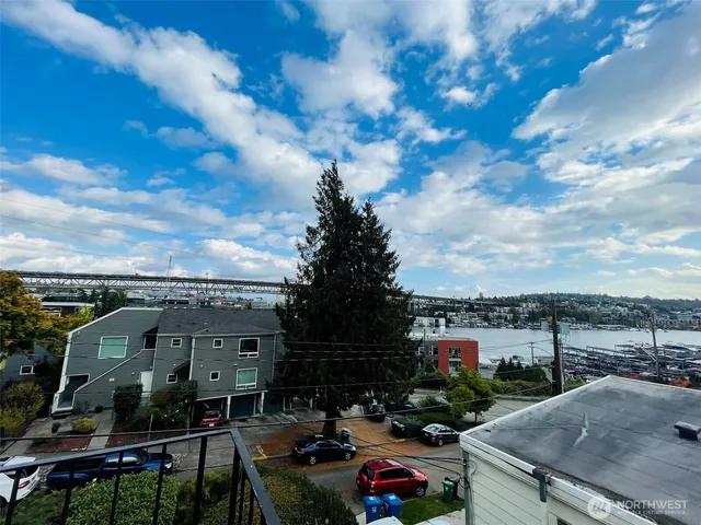 a kitchen with stainless steel appliances a sink a stove a chimney and a dining table with wooden floor