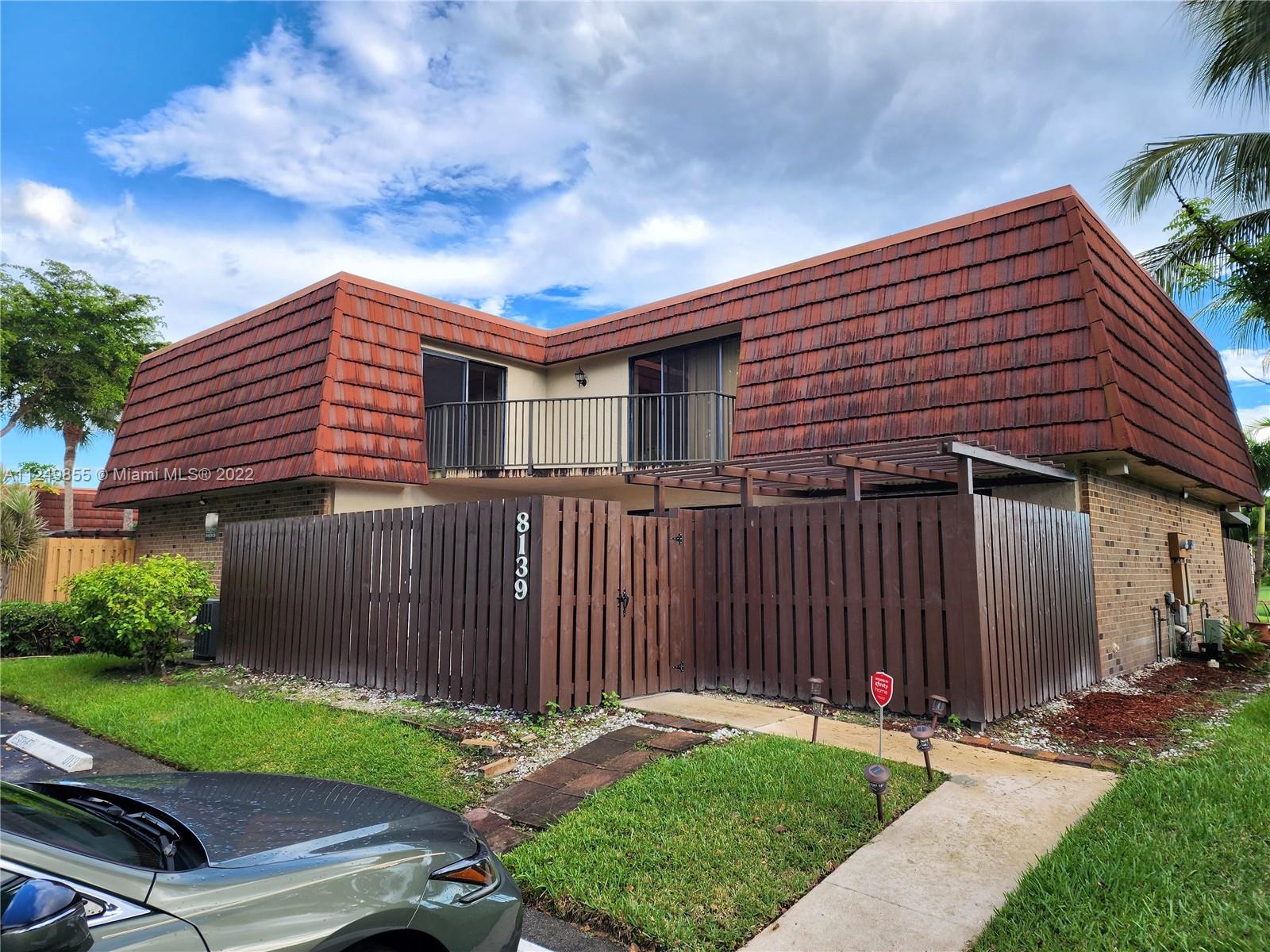 8139 Boca Rio Drive, Unit 8139 Boca Raton, FL 33433 - Photo 2 of 23 a backyard of a house with a garden and deck