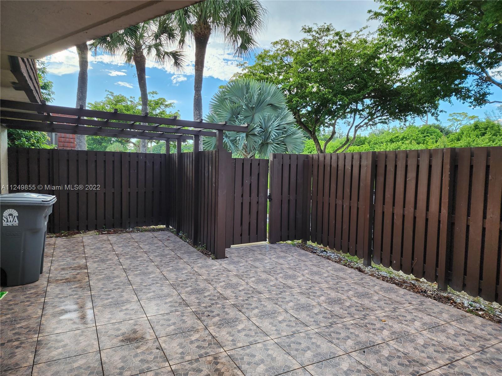 8139 Boca Rio Drive, Unit 8139 Boca Raton, FL 33433 - Photo 5 of 23 a view of backyard with wooden fence and trees